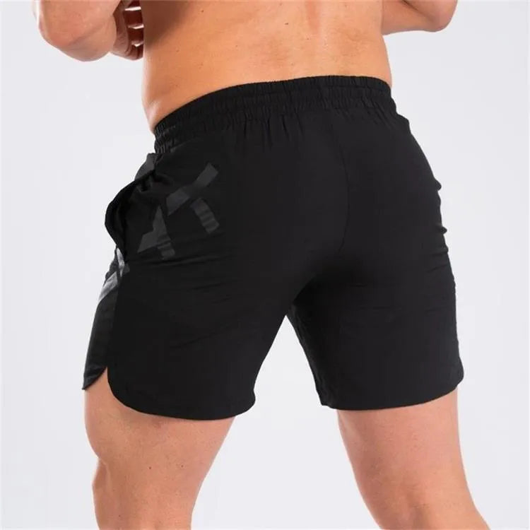 Man wearing black knee-length nylon running shorts during summer training.