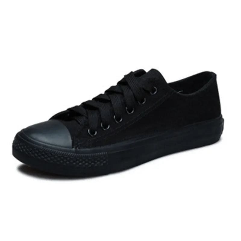 Women's solid colour canvas slip-on shoes in black, white, and red variations on a plain background.