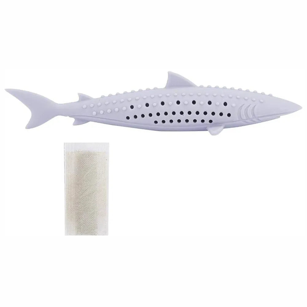 Green silicone fish-shaped cat chew toy with breathable side holes on wooden floor