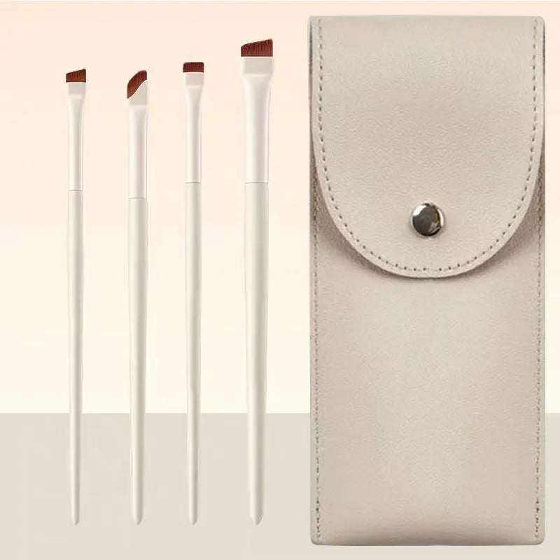 Four angled eyeliner and brow brushes with fine tips next to a leather case.