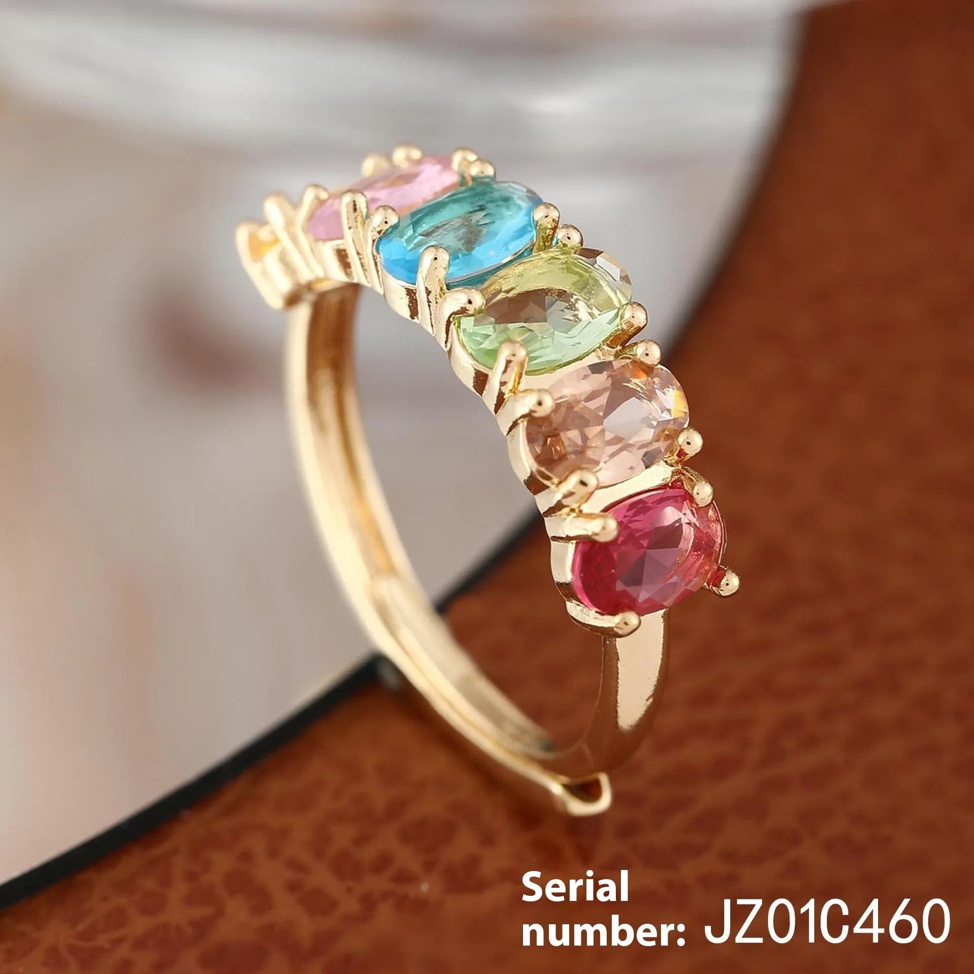 Gold electroplated women's zircon ring with adjustable size on display