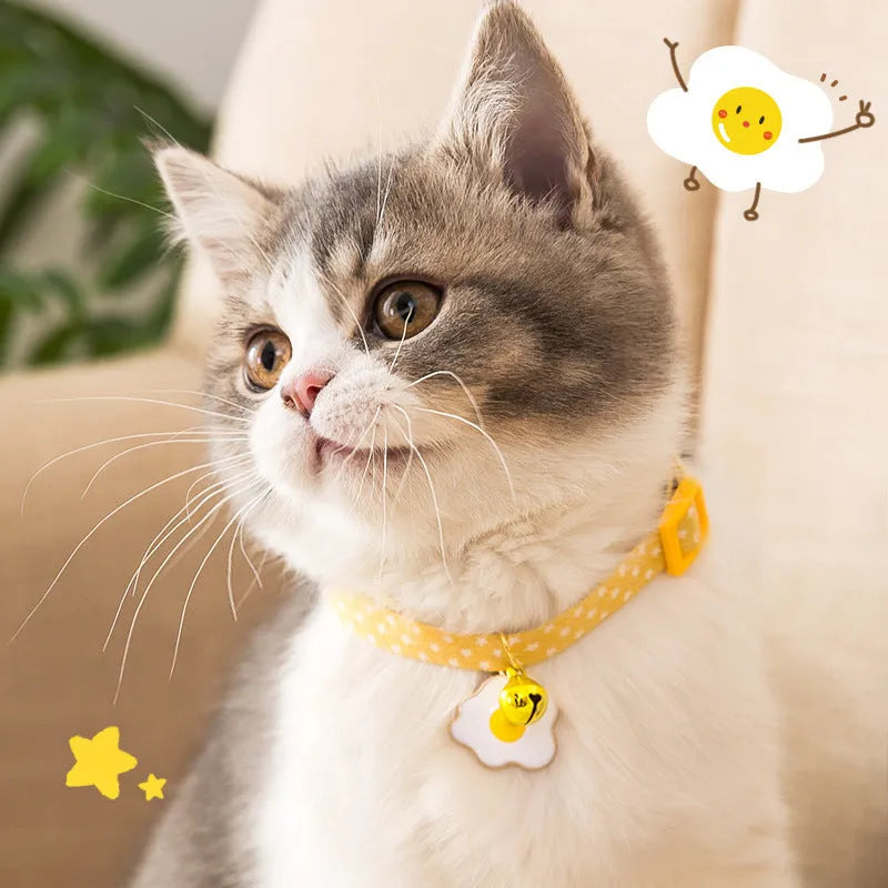 Green adjustable cat collar with a metal bell pendant and a matching bow tie on a white background.