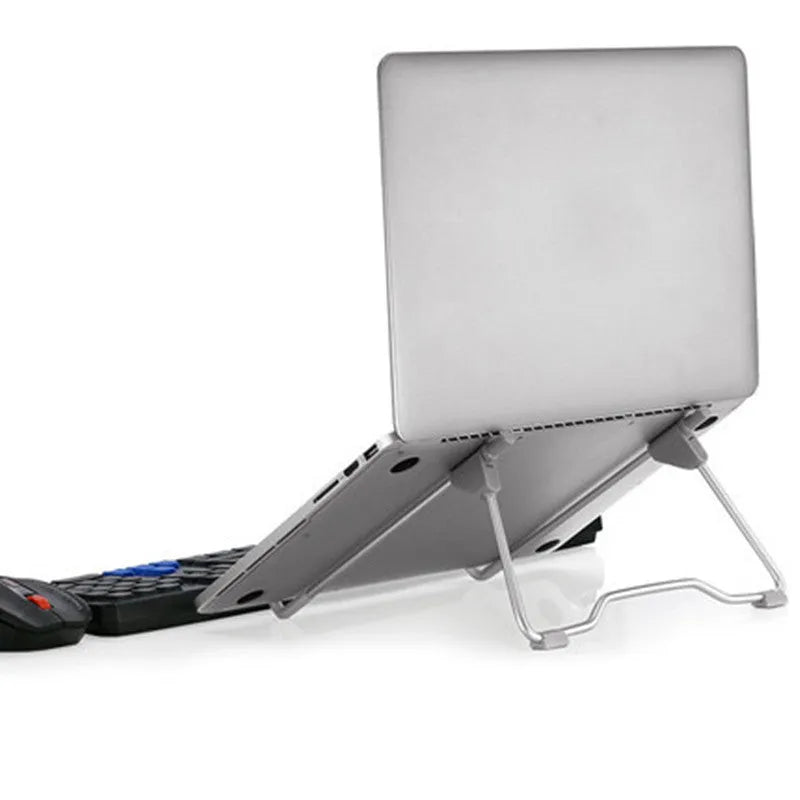 Grey adjustable aluminium and plastic stand holding a mobile phone and a laptop.