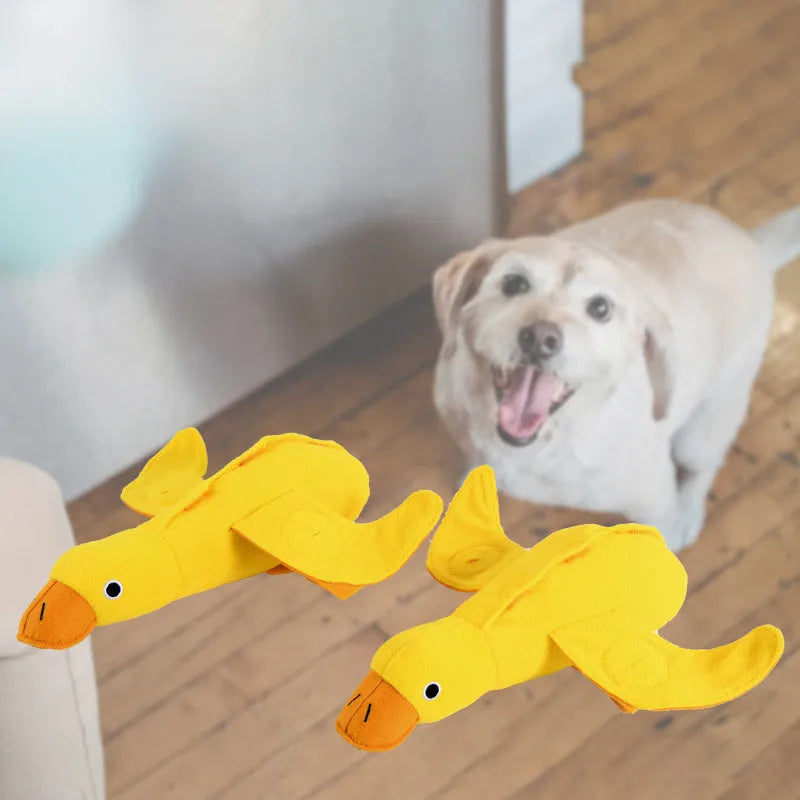 Yellow plush duck dog toy with a sound module and treat-dispensing openings.