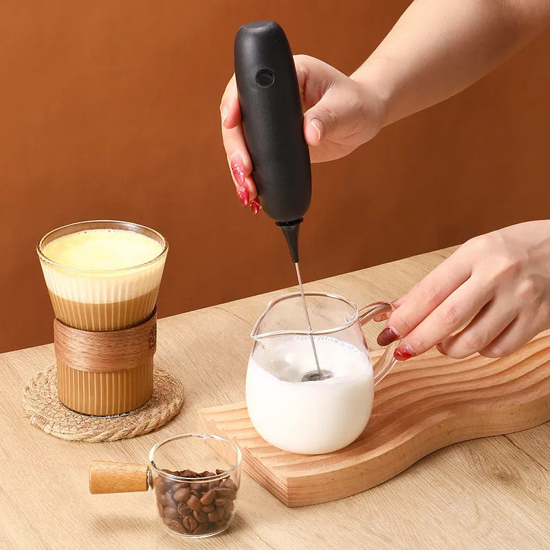 Black and white electric milk frother handheld blender for coffee drinks