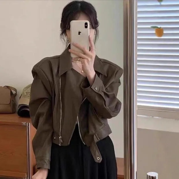 Women's slim-fit short brown retro leather jacket with long sleeves and a pocket.