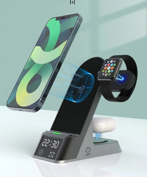 Black six-in-one wireless charging alarm clock station on a desk next to a phone and smartwatch.