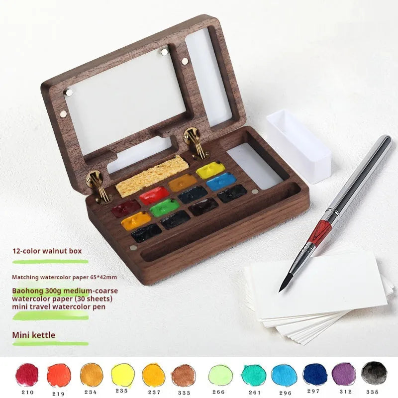 Mini walnut wooden watercolour paint box set with leather carry case, open to show professional artist pigments.