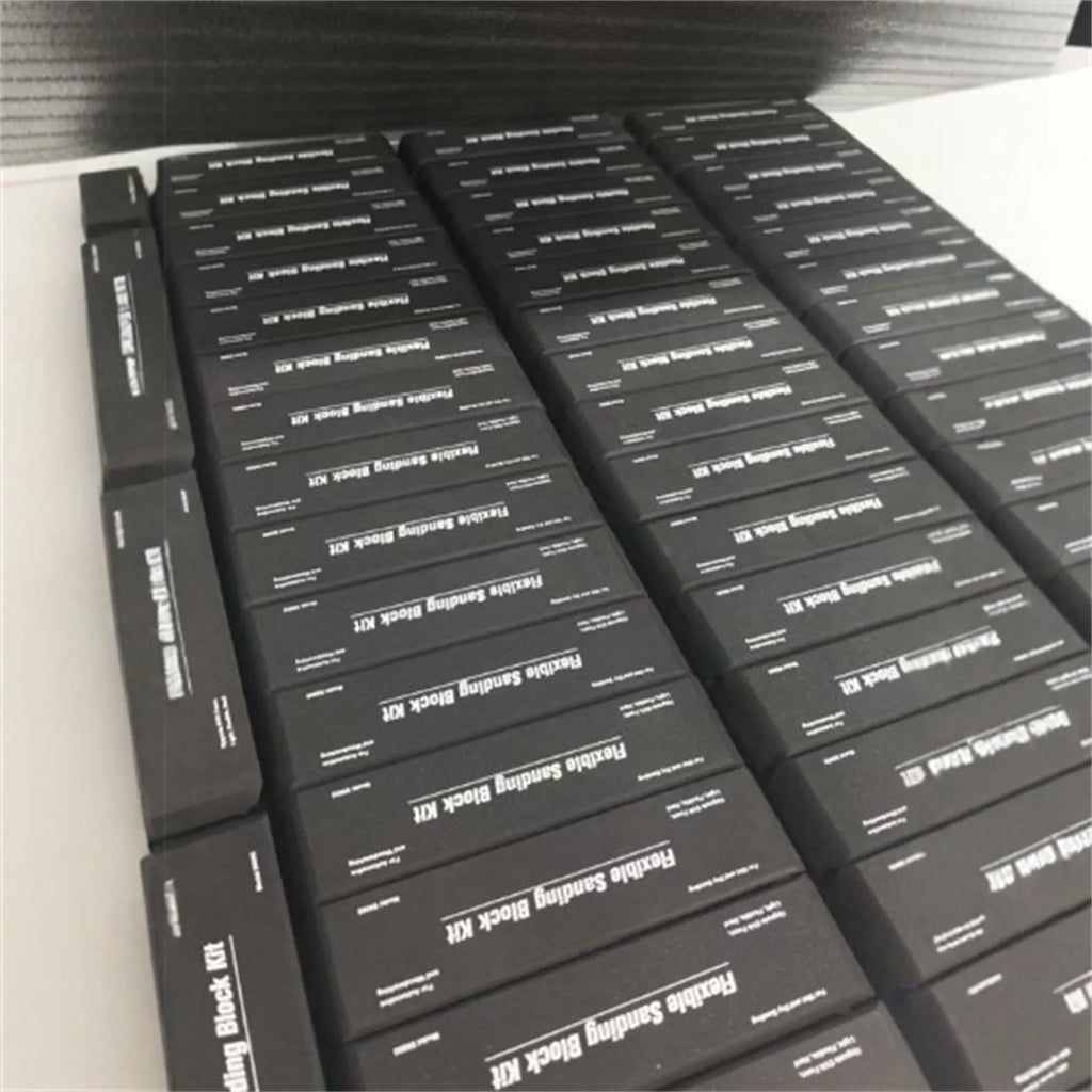 Seven black frosted EVA building blocks with metal connectors on a white surface.