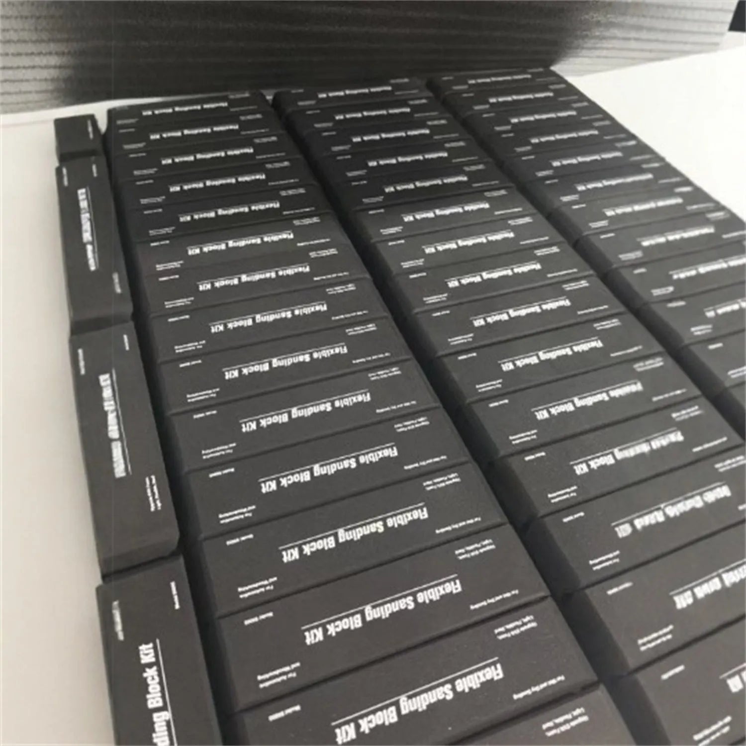 Seven black frosted EVA building blocks with metal connectors on a white surface.