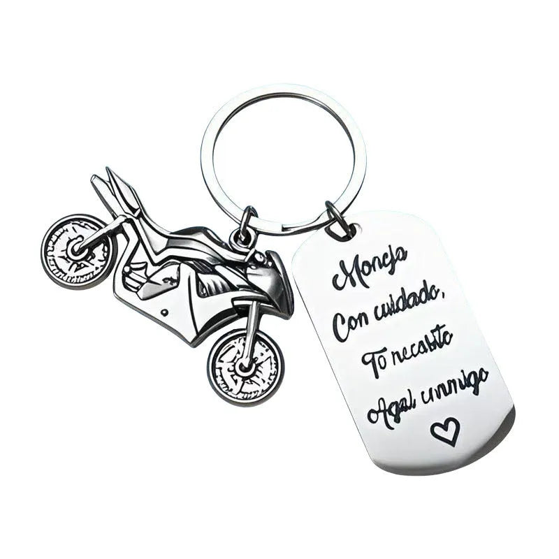 Polished stainless steel motorcycle key ring with inspirational charm on a flannel bag.
