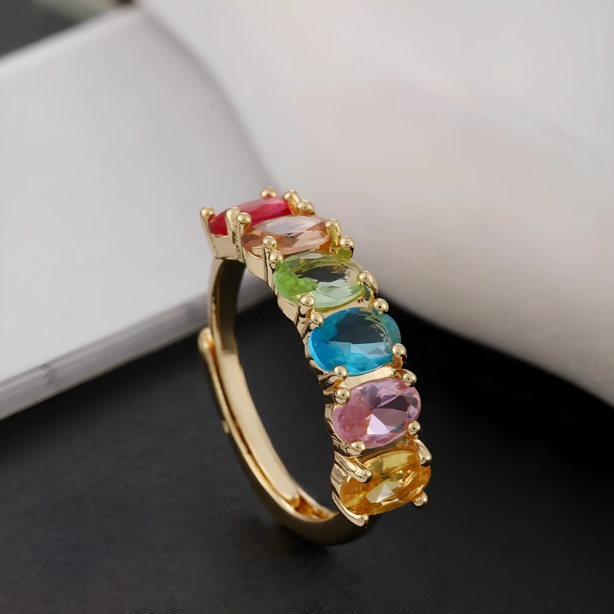 Gold electroplated women's zircon ring with adjustable size on display