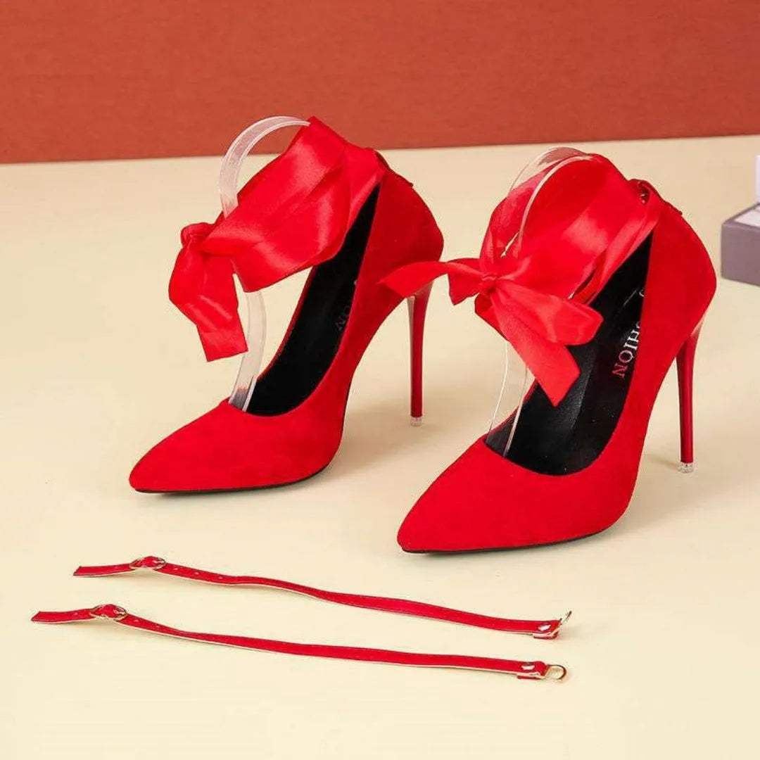 Black pointed toe high heel pump with a lace strap across the foot on a 12cm heel.