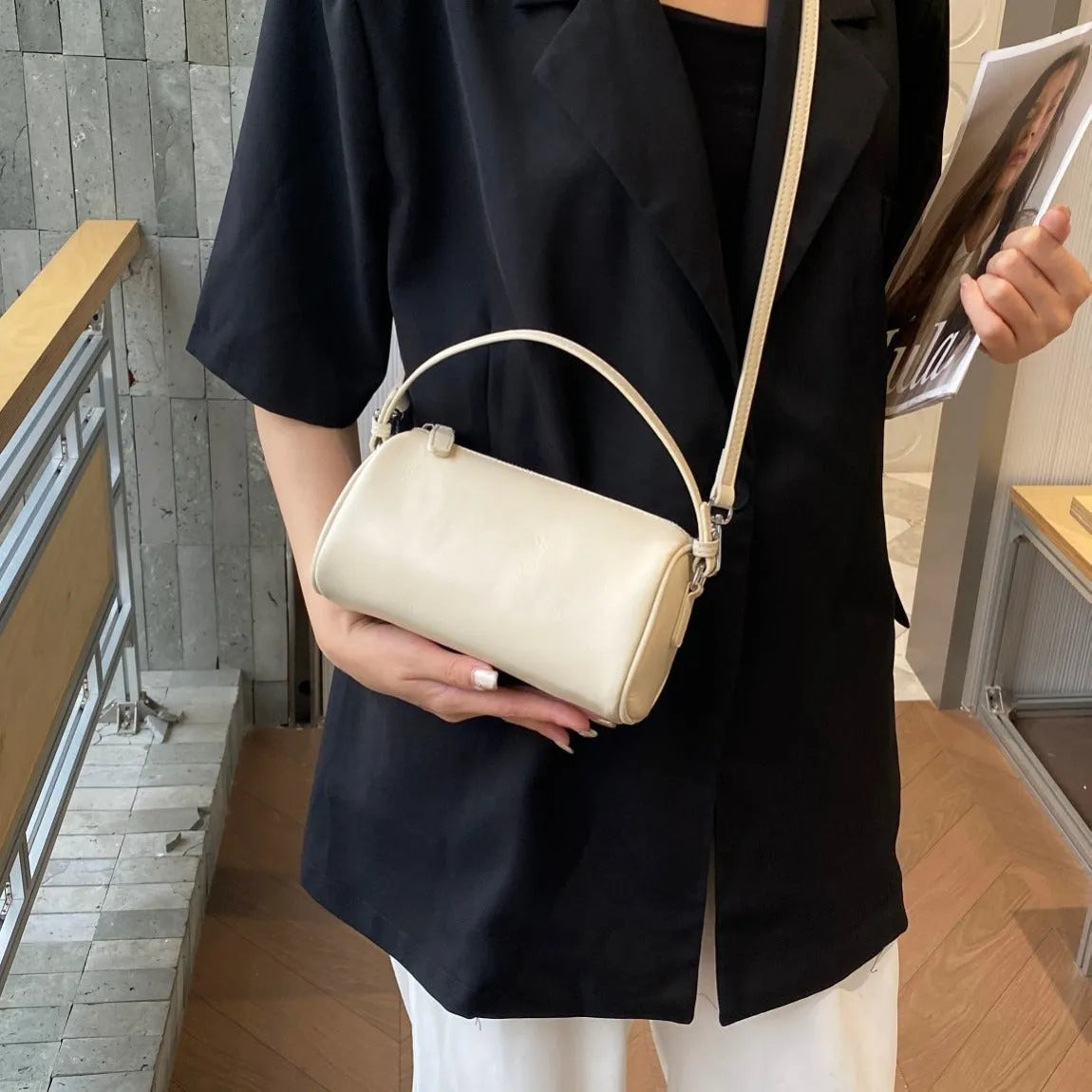Soft genuine leather cylindrical crossbody bag in street style, shown in black, with a single strap.