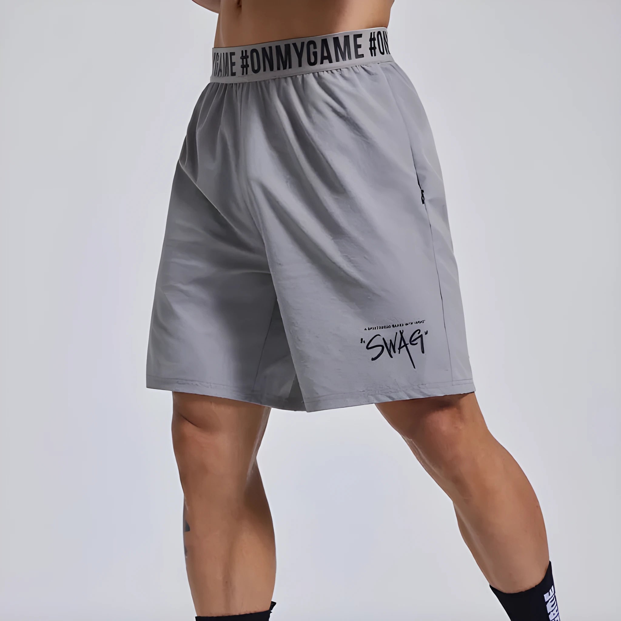 Men's loose grey athletic shorts with an elastic fly opening and letter print, shown from the front.