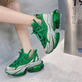 Women's green leather sports shoes with a thick clear jelly sole and white cross-tie laces.