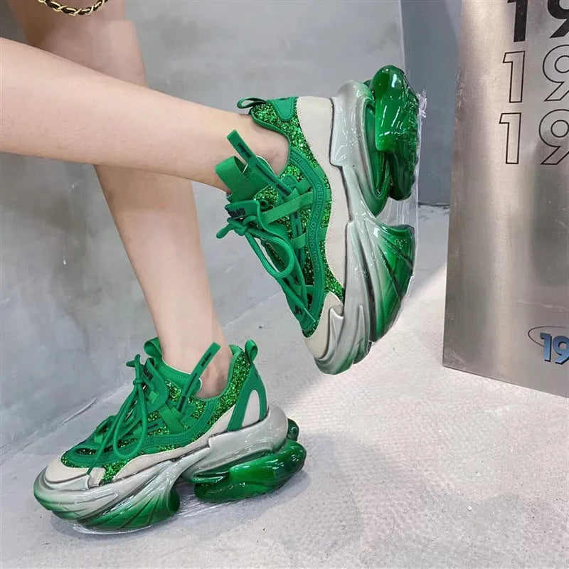 Women's green leather sports shoes with a thick clear jelly sole and white cross-tie laces.