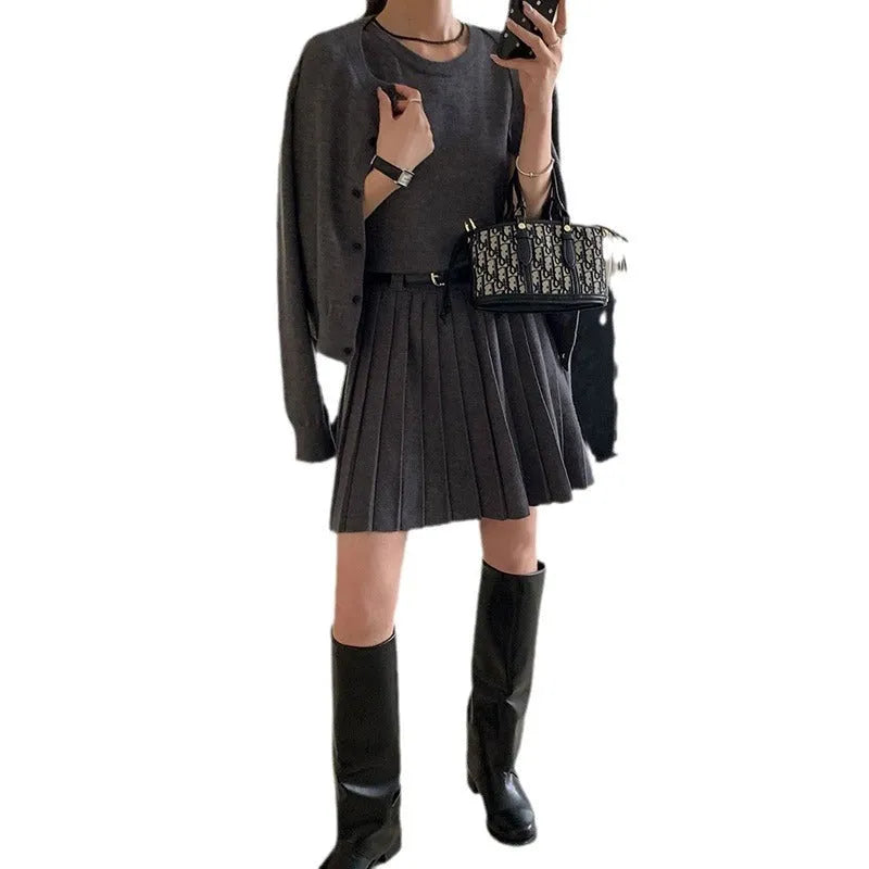Women's black knitted polyester vest skirt and long sleeve cardigan two-piece set with a belt.