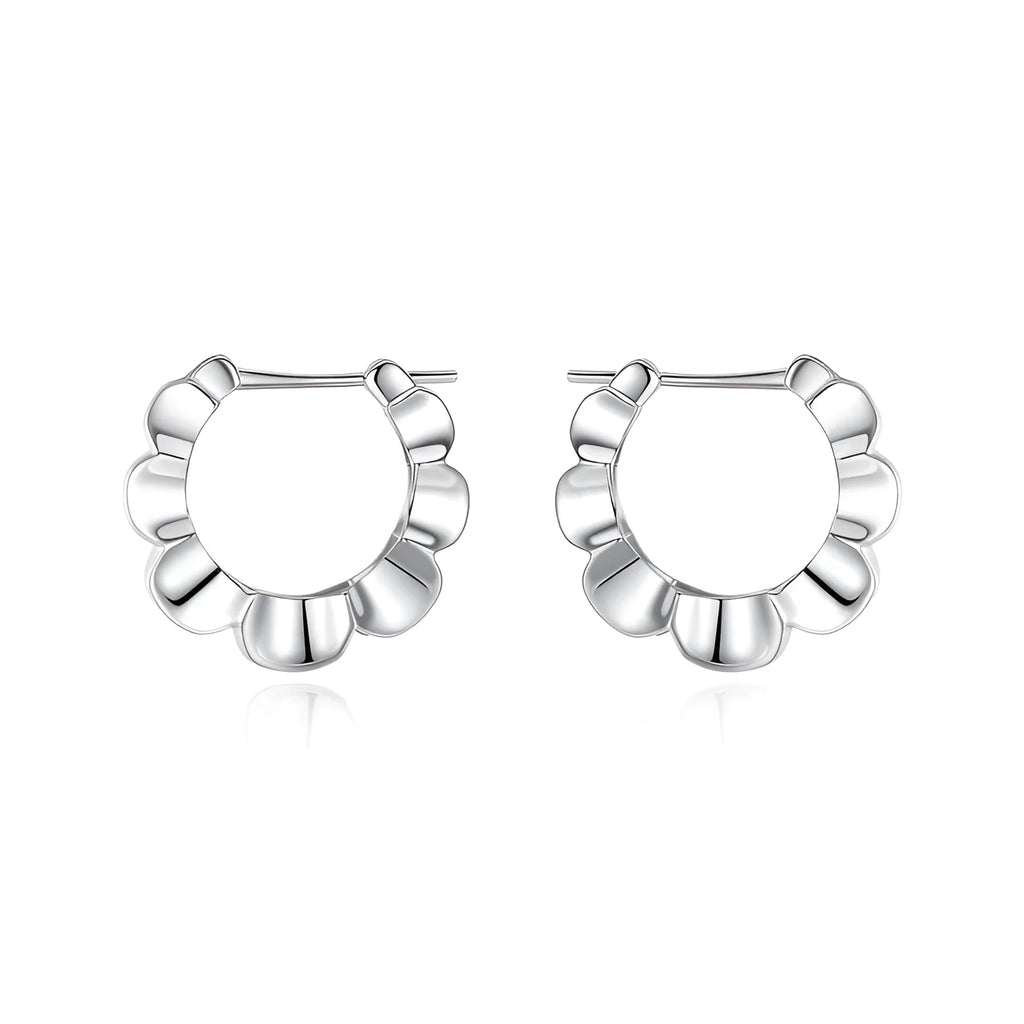 A pair of sterling silver geometric earrings with round details on a simple background.
