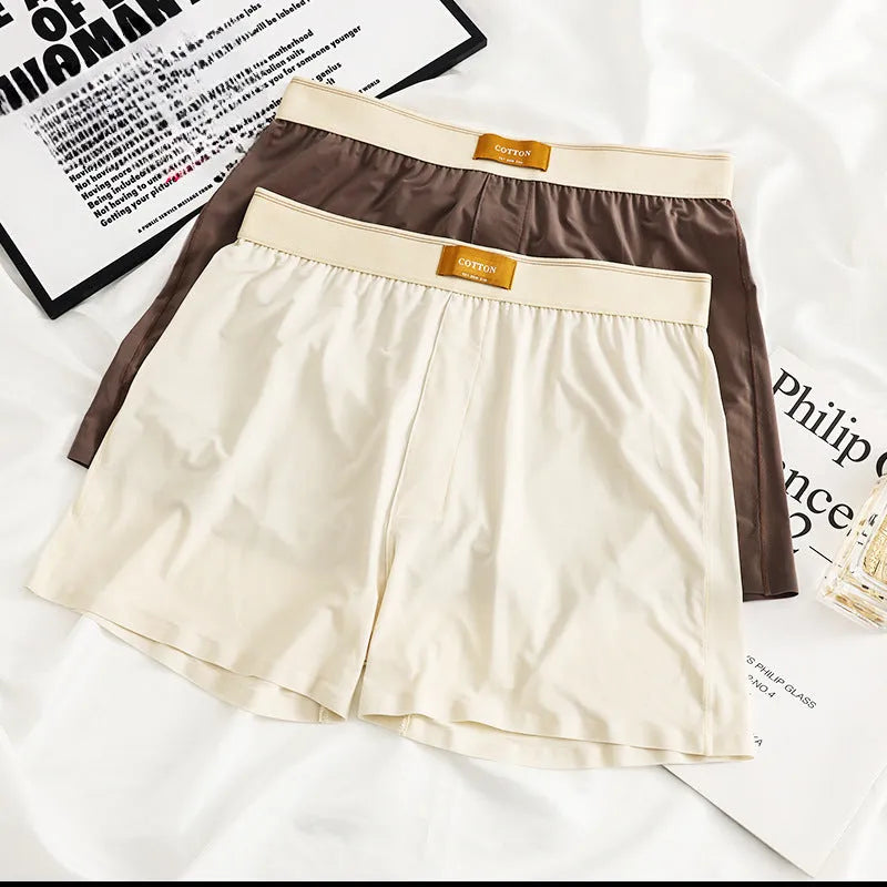 Pack of three men's solid colour loose fit ice silk underwear briefs on a grey background.