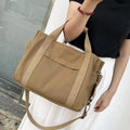 Large khaki canvas tote bag for women with open top showing internal laptop and camera pockets