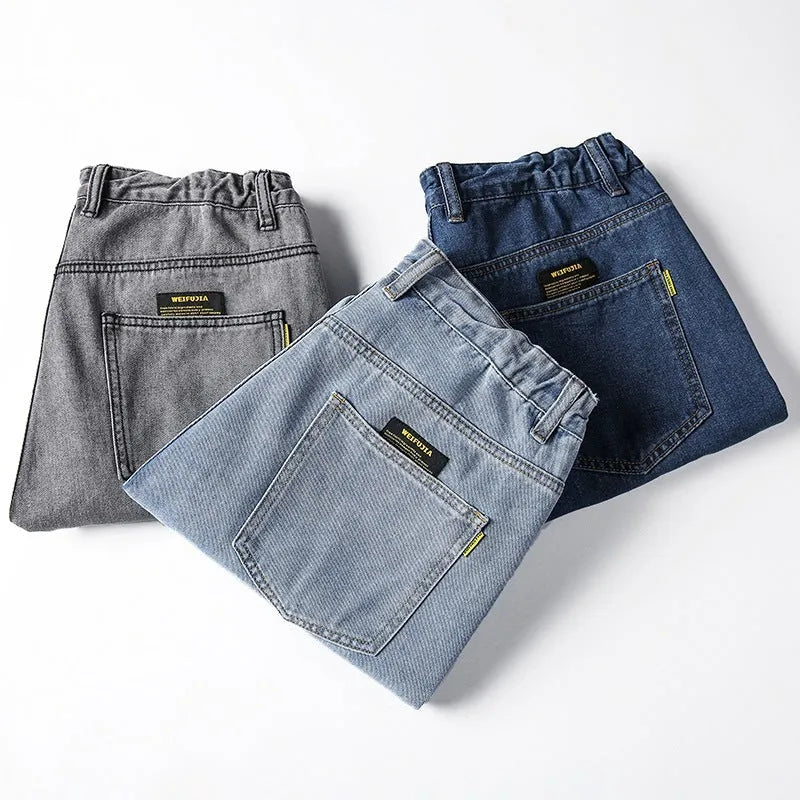 Man wearing loose straight-leg casual jeans in dark blue cotton fabric.