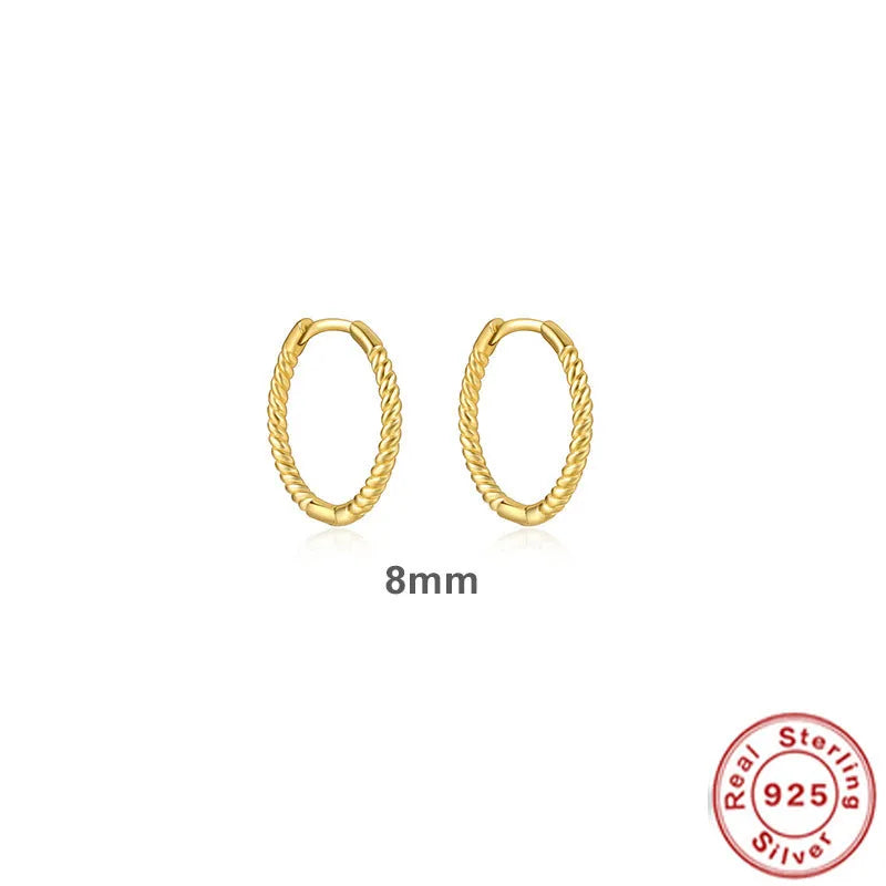 A pair of twisted sterling silver round earrings in a geometric design on a white background.