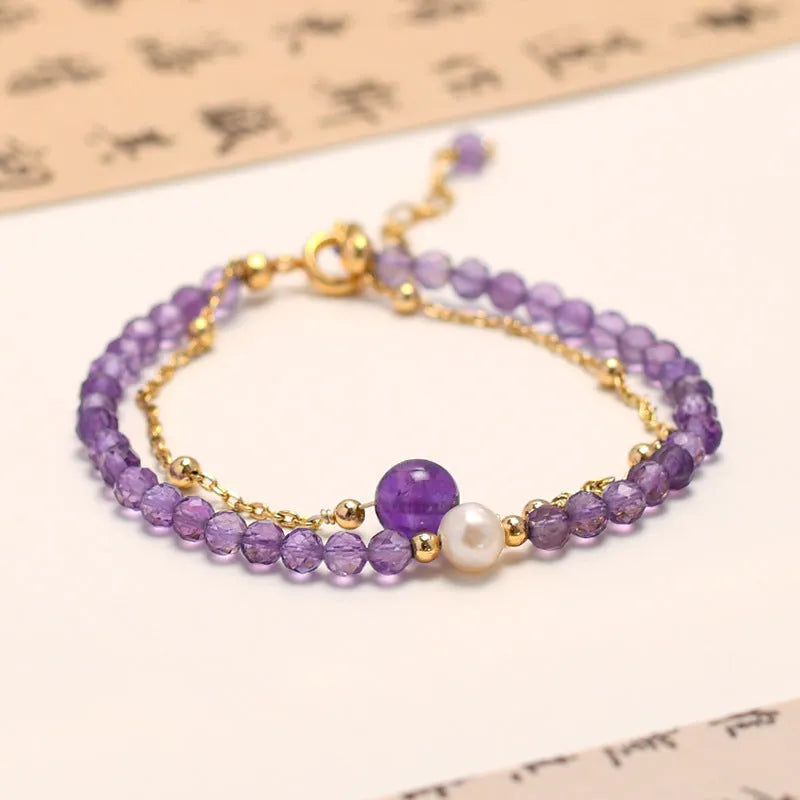 Close-up of a Chinese style women's bracelet with a diamond-shaped amethyst crystal on an electroplated chain.