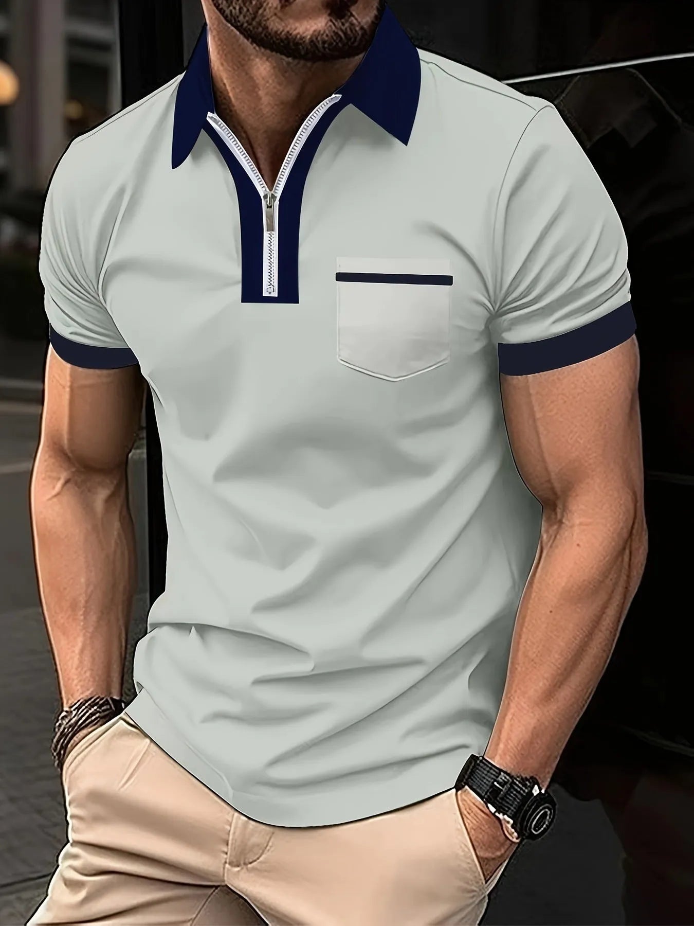 Man wearing a loose-fit casual short sleeve shirt with a chest pocket and zipper decoration.