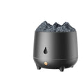 Black volcano-shaped ultrasonic humidifier with USB cable on a wooden table, emitting a plume of mist.