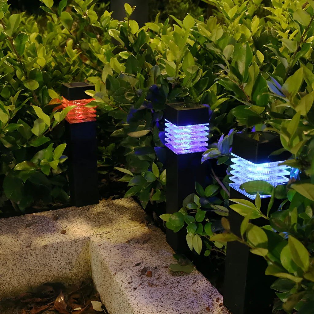 White cuboid solar-powered ground lamp for garden pathways with a solar panel on top.