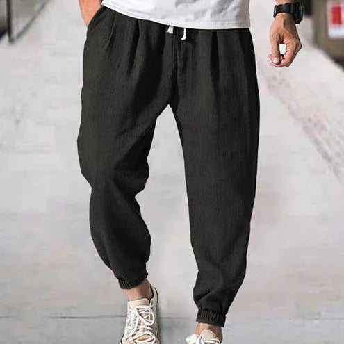 Men's loose casual cotton trousers with an elasticated ankle band in light green.