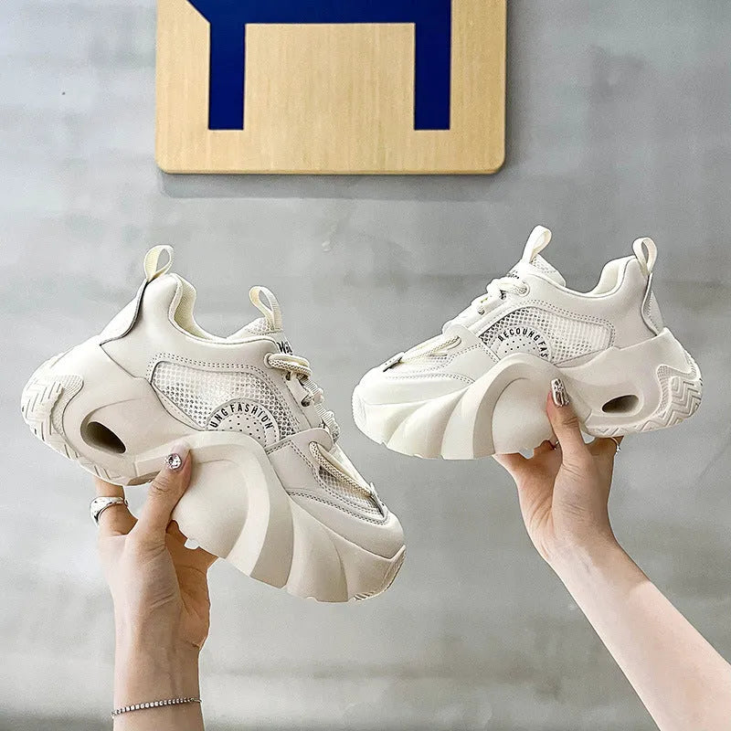 Women's pink sneakers with cross straps and a thick white platform sole.