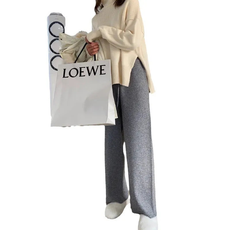 Women's cream white thick knitted wide-leg trousers with a high waist and drooping hem laid flat.