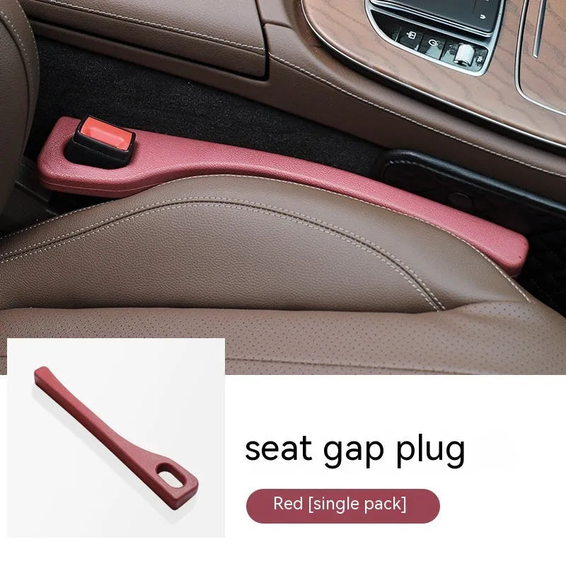 A flexible polyurethane car seat gap filler strip in black, placed between a car seat and centre console.
