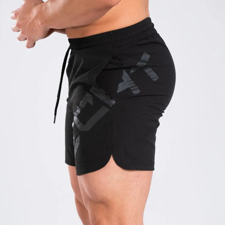 Man wearing black knee-length nylon running shorts during summer training.