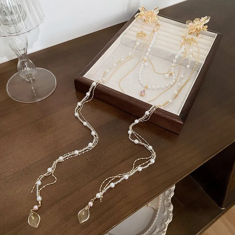 Gold grip hairpin for women with pearl, diamond, flower decorations and a long tassel.