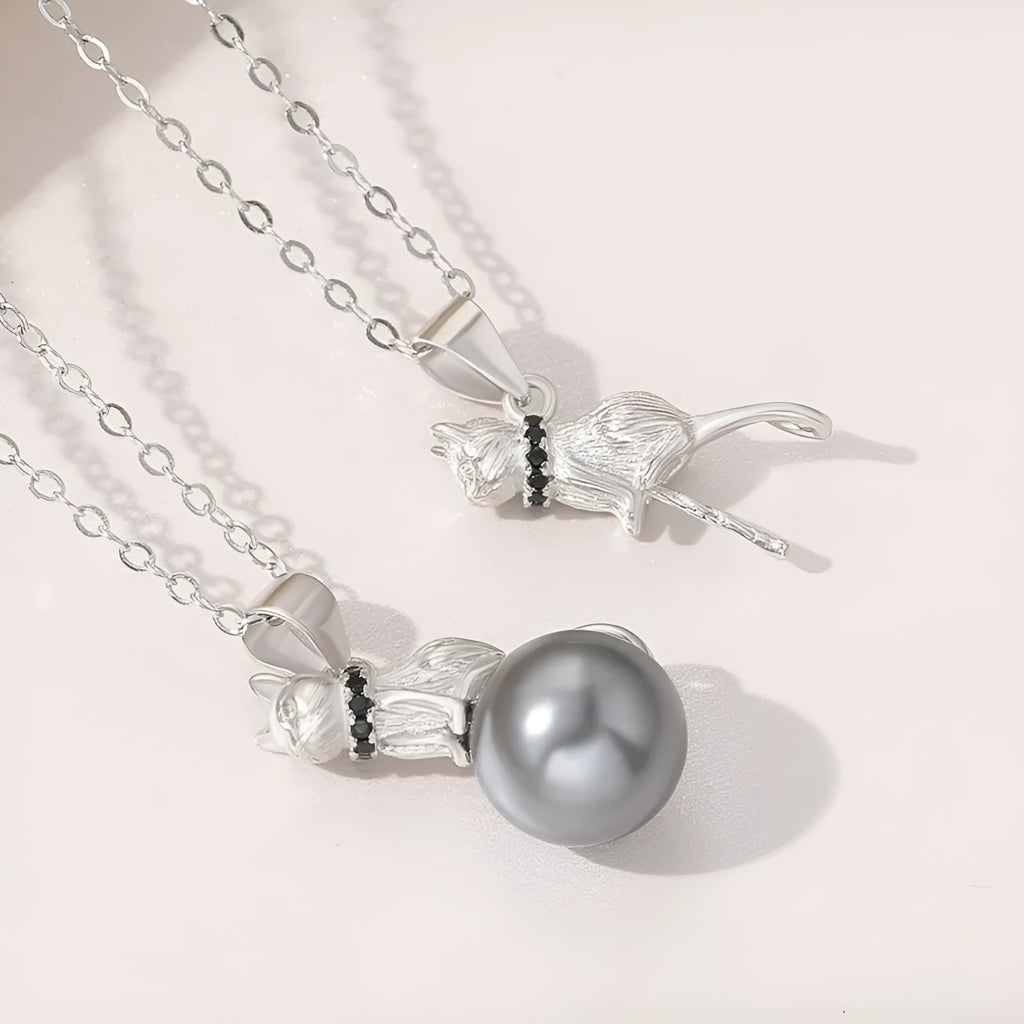 Close-up of a sterling silver cat silhouette pendant on a delicate silver chain.