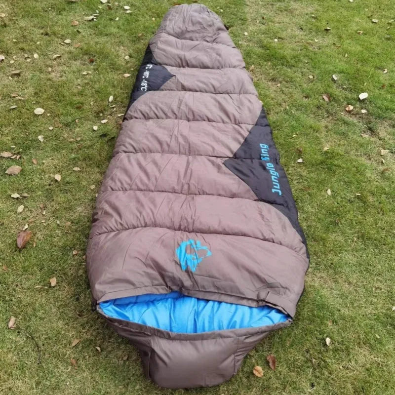 Outdoor cotton sleeping bag in army green, shown next to its grey compression storage sack