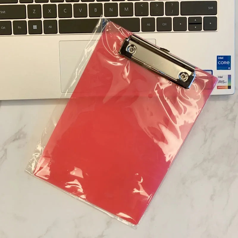 Transparent A4 writing board pad with metal clip holding paper, shown in blue colour variant.