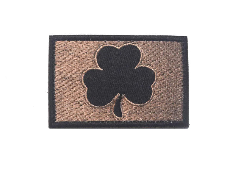 Outdoor embroidered fabric badge with Velcro strip backing on a green clover design.