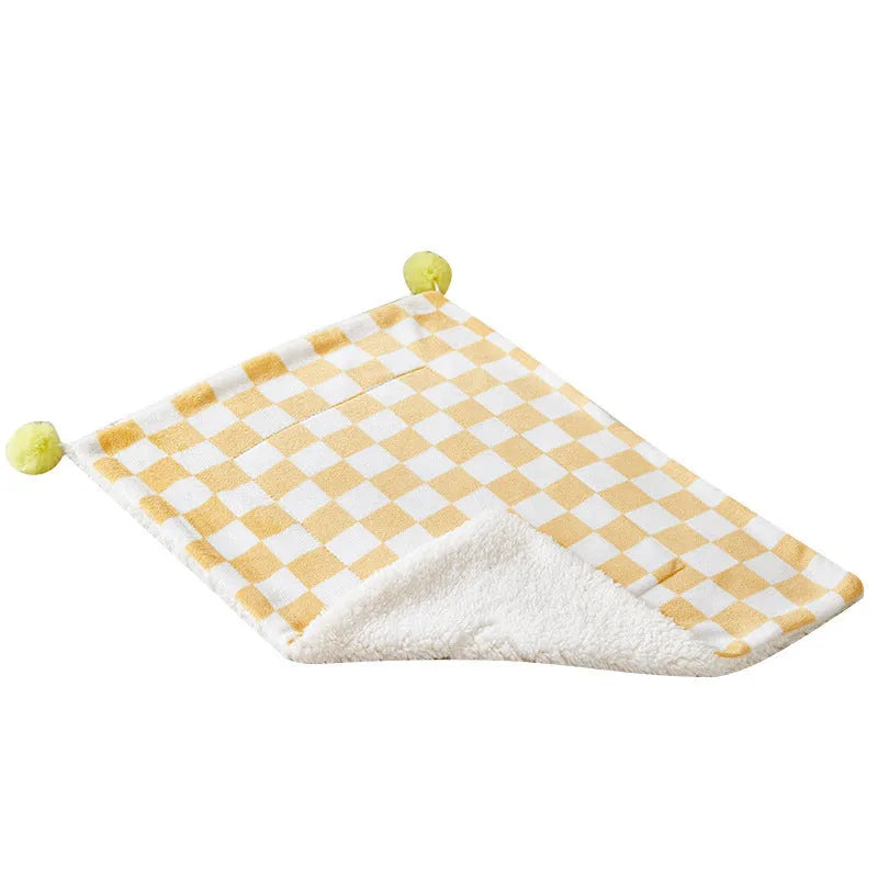 Plush pet blanket with plaid pattern and decorative fur ball in green colour