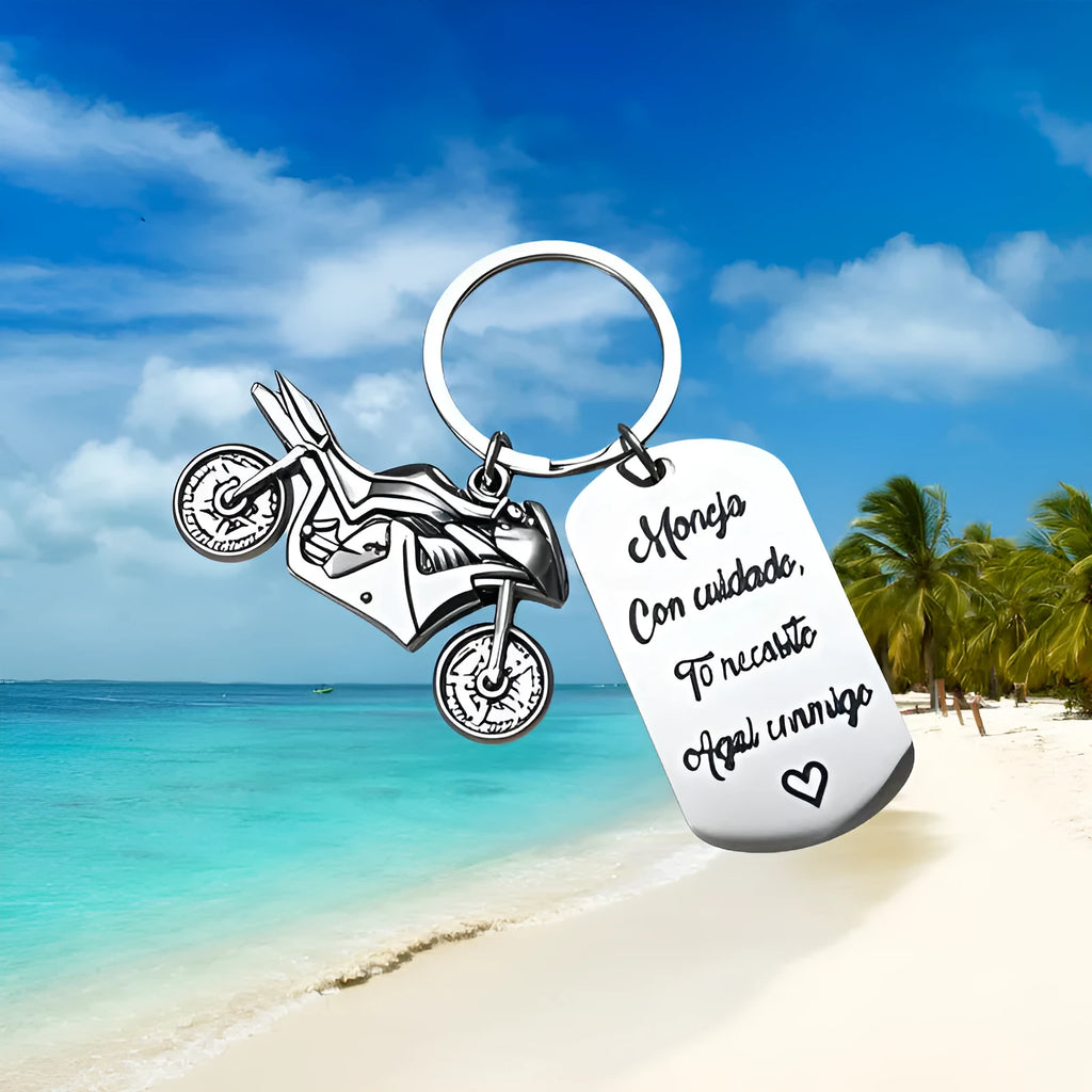 Polished stainless steel motorcycle key ring with inspirational charm on a flannel bag.