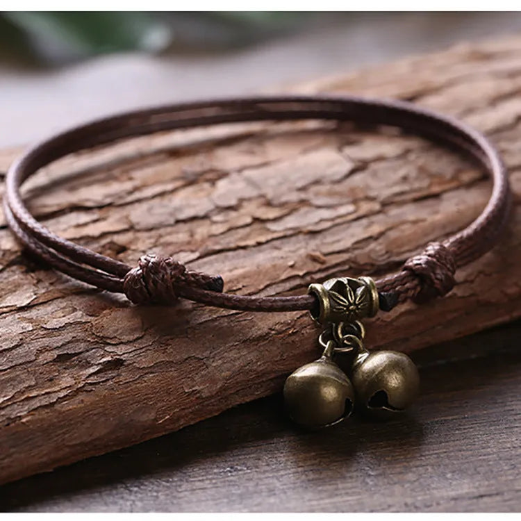 Close-up of a black nylon rope dog collar for small dogs, featuring a shining brass bell.