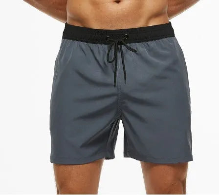 Men's blue running shorts with stitching waistband, zipper pocket, and drawstring for fitness activities