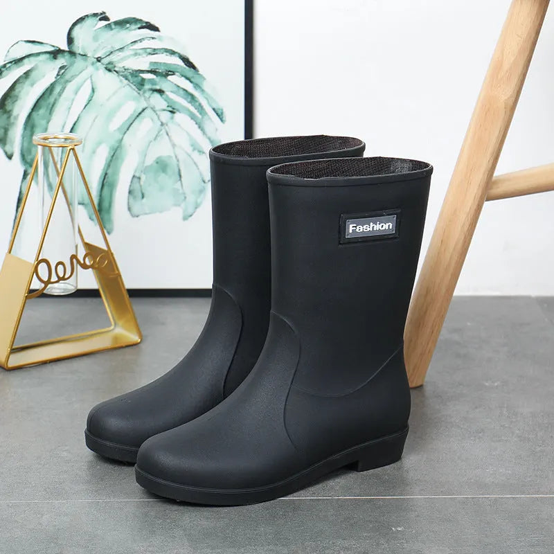 Women's mid-calf PVC rain boot in black with a low heel on a white background.