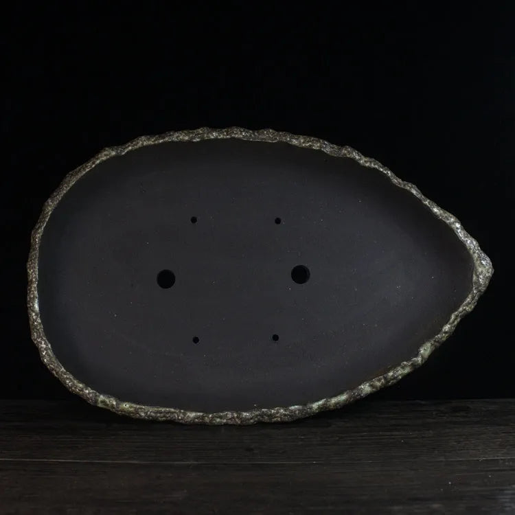 Handmade purple clay flower pot showing unique shape and traditional ceramic texture