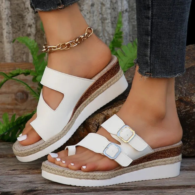 White patent leather women's wedge sandals with woven finger fit straps and a peep toe.