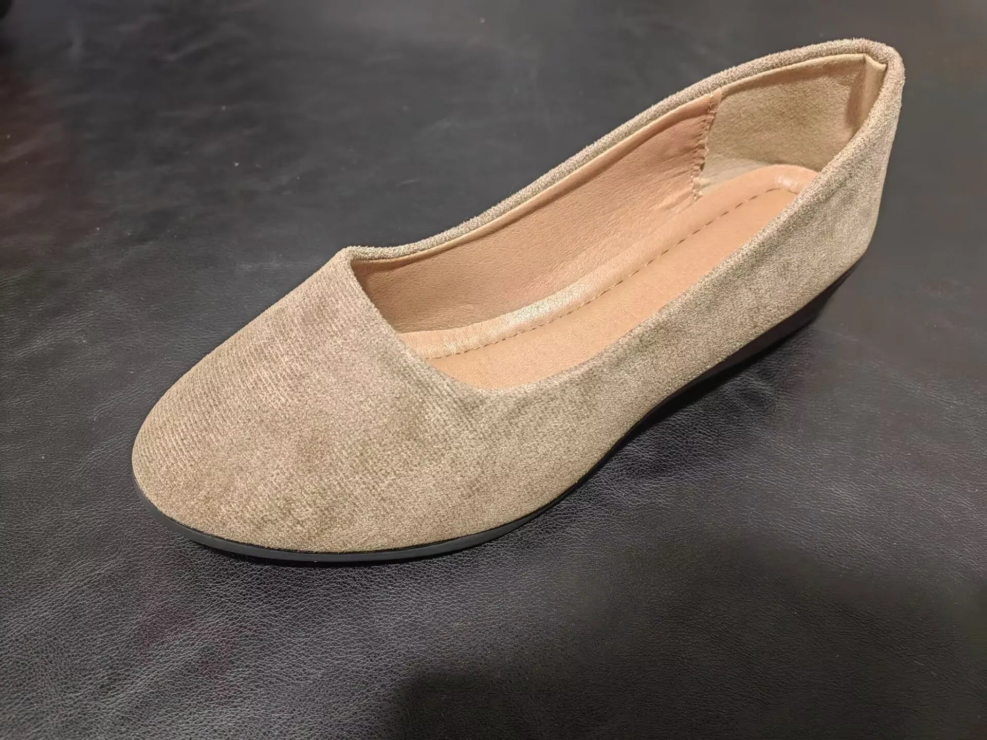 Women's suede wedge pump in light brown with a pointed toe and low rubber sole.