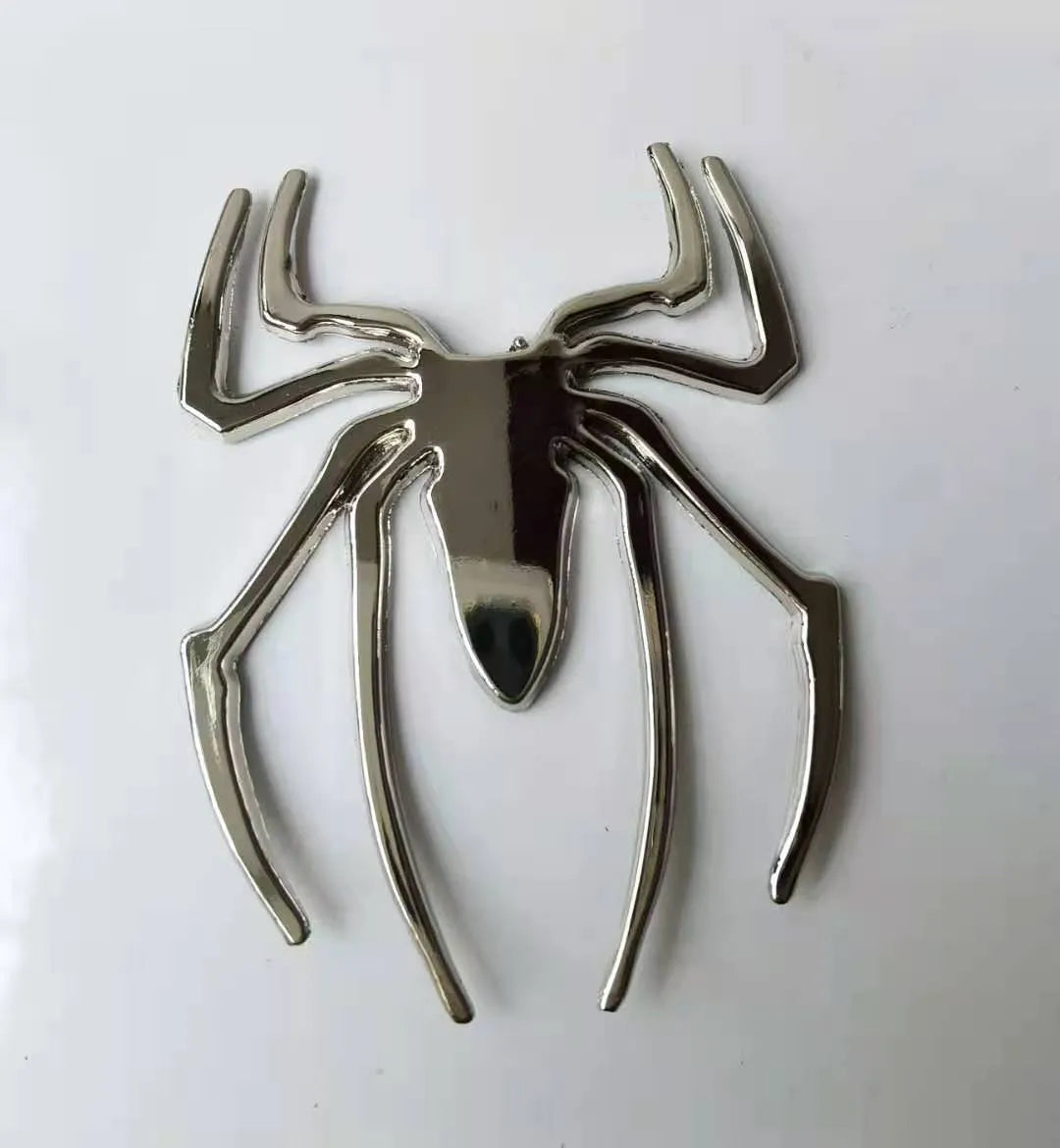 Three-dimensional metal spider bumper sticker in zinc alloy, shown in gold colour.